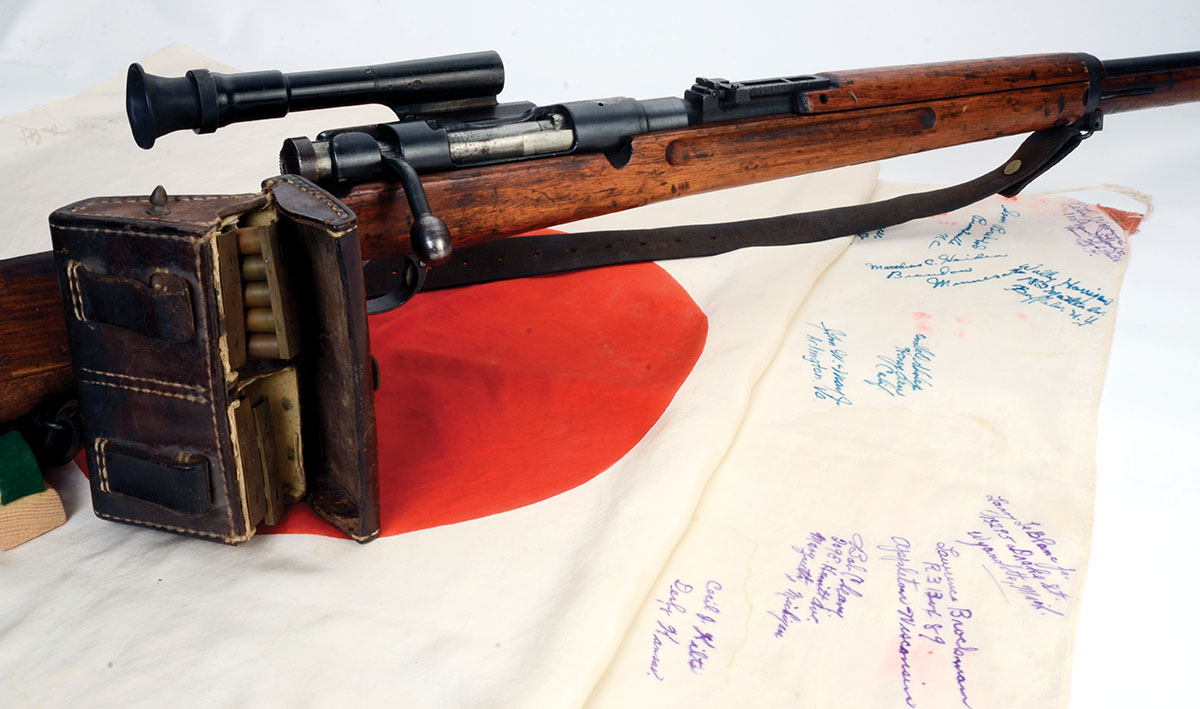 Mike’s Japanese Type 97 6.5x 50mm is shown with a leather ammunition pouch and a captured flag signed by the Americans who took it in battle.